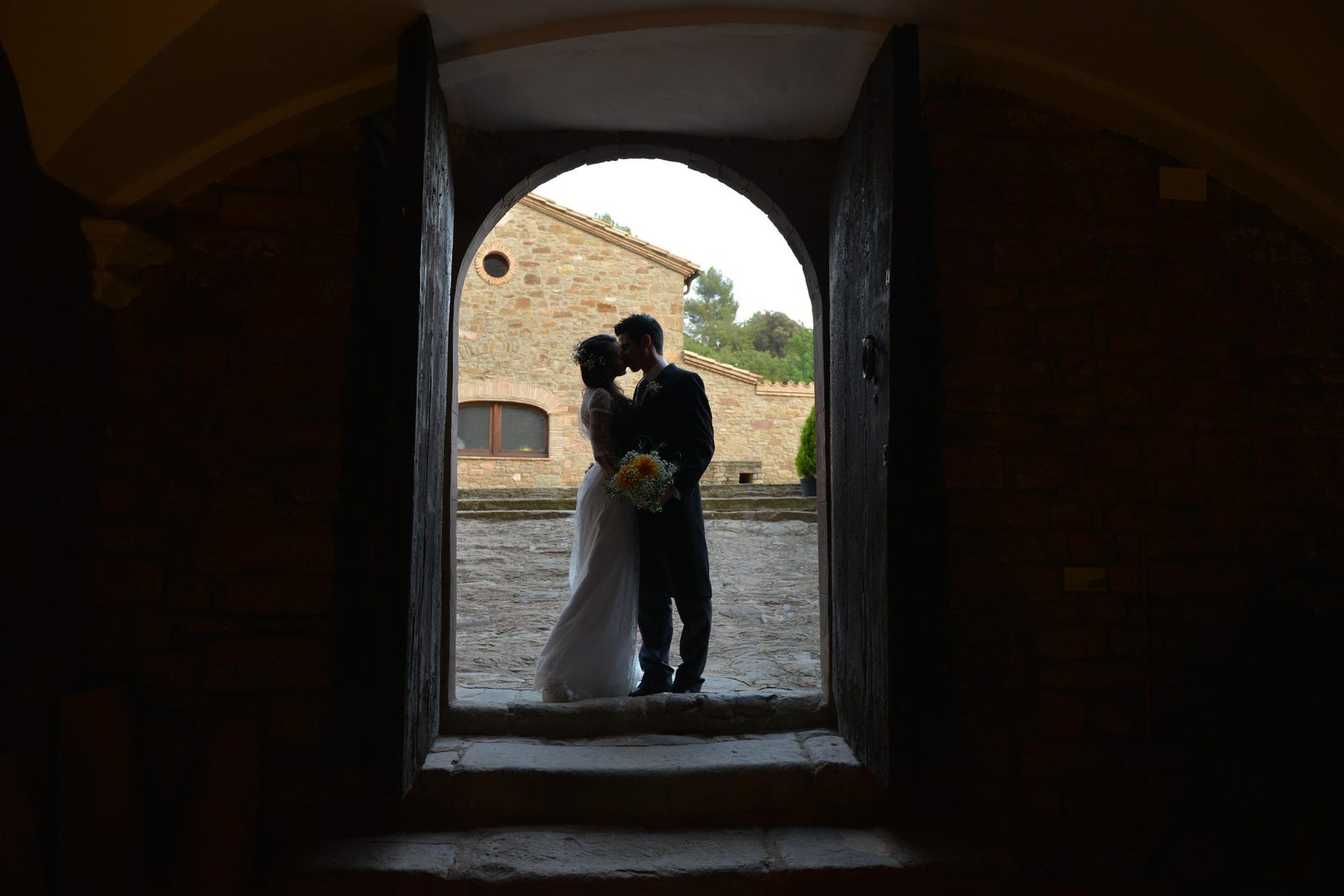 Detalle de manos de los novios con el ramo