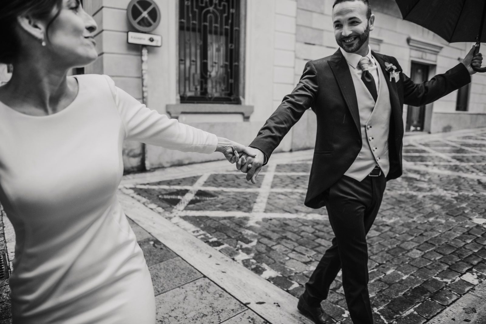 Novios corriendo en blanco y negro por las calles de Barcelona