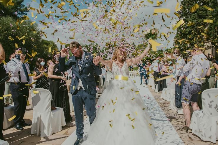 Salida de novios entre confeti dorado tras la ceremonia