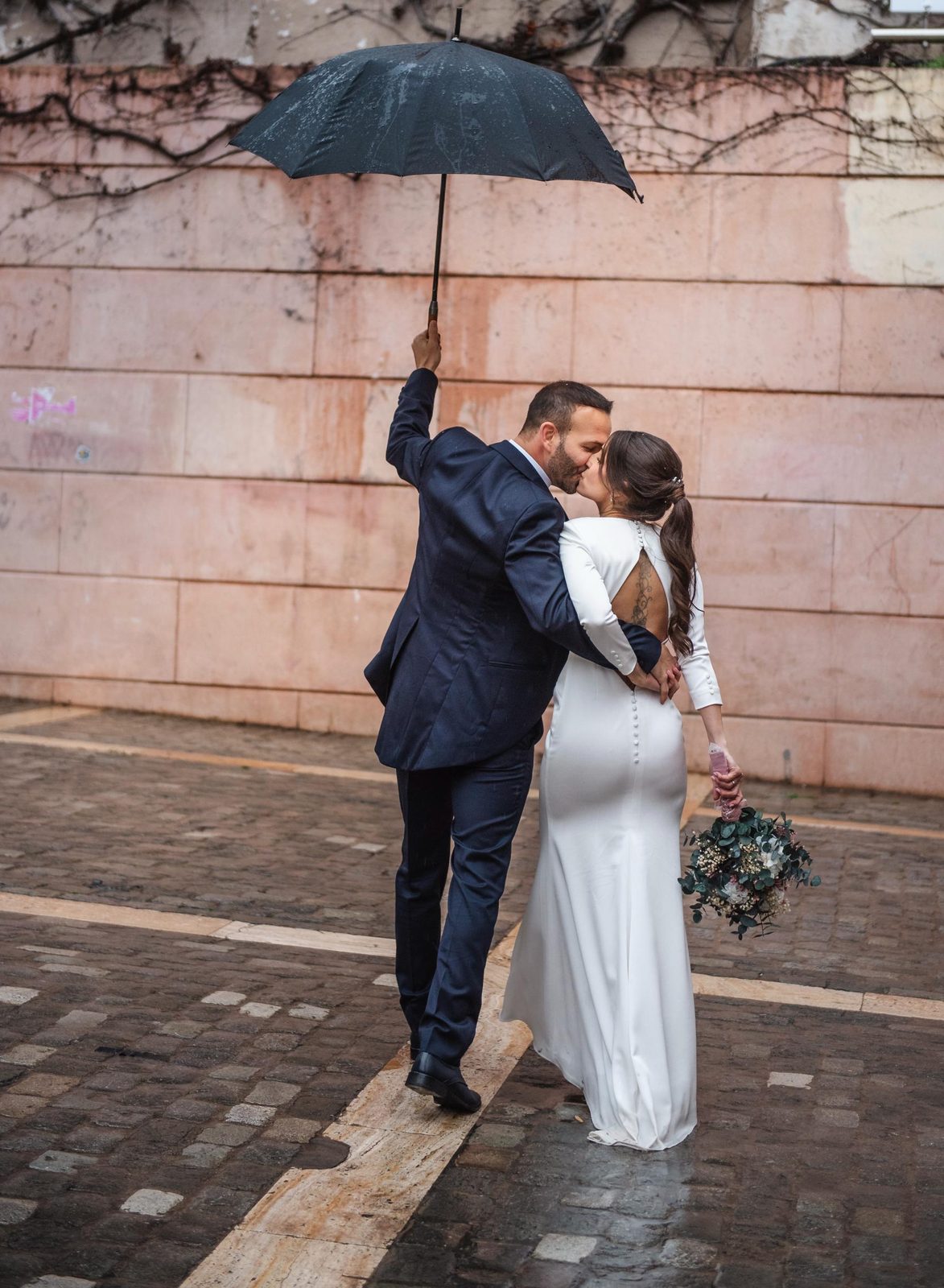 Novios besándose bajo paraguas en Mataró